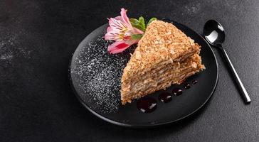 Fresh delicious cake napoleon with cream on a dark background photo