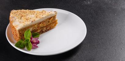 Fresh delicious carrot cake with cream on a dark background photo