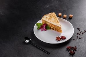 Fresh delicious carrot cake with cream on a dark background photo