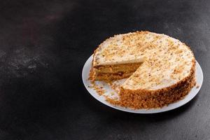 Fresh delicious carrot cake with cream on a dark background photo