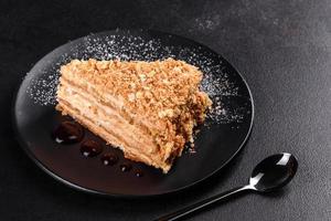 Fresh delicious cake napoleon with cream on a dark background photo