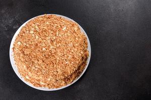 Fresh delicious cake napoleon with cream on a dark background photo