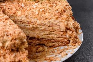 Fresh delicious cake napoleon with cream on a dark background photo