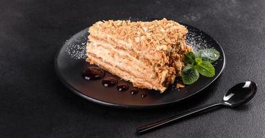 Fresh delicious cake napoleon with cream on a dark background photo