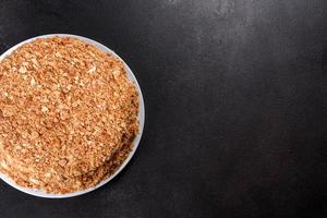 Fresh delicious cake napoleon with cream on a dark background photo