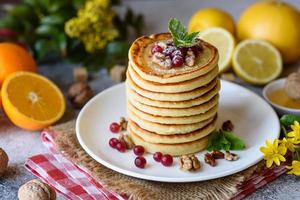 Delicious fresh beautiful pancakes with citrus honey and jam photo