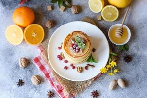 Delicious fresh beautiful pancakes with citrus honey and jam photo