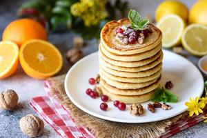 Delicious fresh beautiful pancakes with citrus honey and jam photo