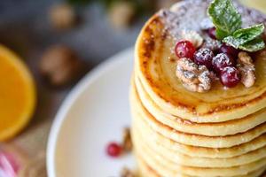 Delicious fresh beautiful pancakes with citrus honey and jam photo