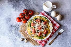 Spaghetti with mushrooms, cheese, spinach, rukkola and cherry tomatoes photo