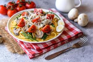 Spaghetti with mushrooms, cheese, spinach, rukkola and cherry tomatoes photo