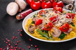 Spaghetti with mushrooms, cheese, spinach, rukkola and cherry tomatoes photo