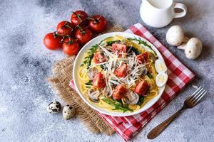 Spaghetti with mushrooms, cheese, spinach, rukkola and cherry tomatoes photo