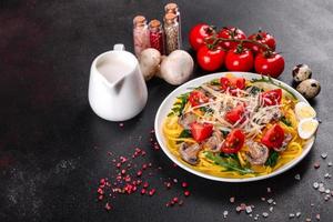 Spaghetti with mushrooms, cheese, spinach, rukkola and cherry tomatoes photo