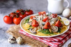 Spaghetti with mushrooms, cheese, spinach, rukkola and cherry tomatoes photo