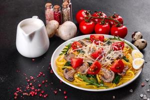 Spaghetti with mushrooms, cheese, spinach, rukkola and cherry tomatoes photo