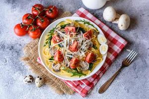 Spaghetti with mushrooms, cheese, spinach, rukkola and cherry tomatoes photo