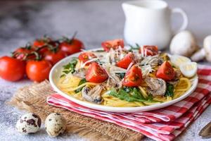 Spaghetti with mushrooms, cheese, spinach, rukkola and cherry tomatoes photo