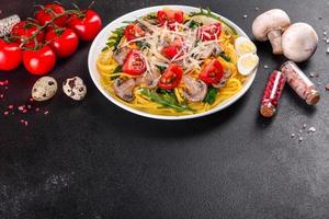 Spaghetti with mushrooms, cheese, spinach, rukkola and cherry tomatoes photo