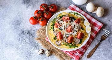 Spaghetti with mushrooms, cheese, spinach, rukkola and cherry tomatoes photo