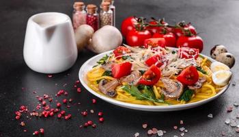 Spaghetti with mushrooms, cheese, spinach, rukkola and cherry tomatoes photo