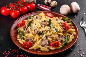pasta con champiñones, queso, espinacas, rukkola y tomates cherry foto