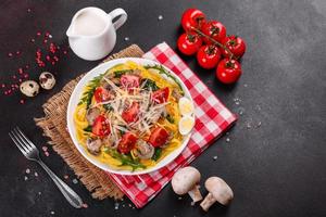 Spaghetti with mushrooms, cheese, spinach, rukkola and cherry tomatoes photo