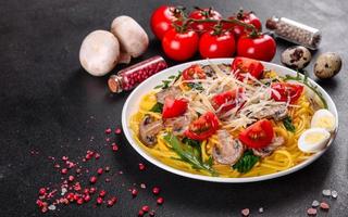 Spaghetti with mushrooms, cheese, spinach, rukkola and cherry tomatoes photo
