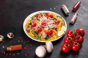 Spaghetti with mushrooms, cheese, spinach, rukkola and cherry tomatoes photo