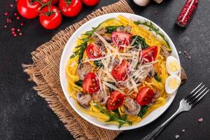 Spaghetti with mushrooms, cheese, spinach, rukkola and cherry tomatoes photo