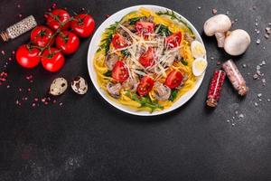 Spaghetti with mushrooms, cheese, spinach, rukkola and cherry tomatoes photo