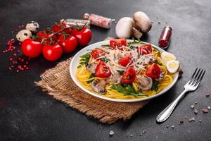 Spaghetti with mushrooms, cheese, spinach, rukkola and cherry tomatoes photo