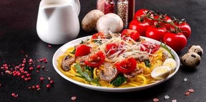 Spaghetti with mushrooms, cheese, spinach, rukkola and cherry tomatoes photo