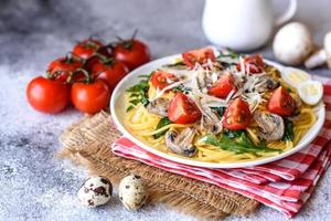 Spaghetti with mushrooms, cheese, spinach, rukkola and cherry tomatoes photo