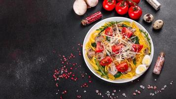 Spaghetti with mushrooms, cheese, spinach, rukkola and cherry tomatoes photo