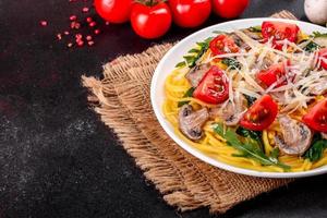 Spaghetti with mushrooms, cheese, spinach, rukkola and cherry tomatoes photo