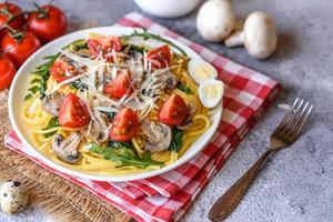 Spaghetti with mushrooms, cheese, spinach, rukkola and cherry tomatoes photo