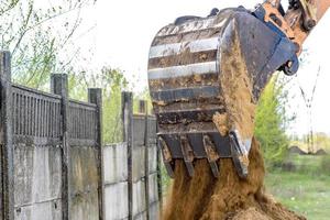 The modern excavator performs excavation work on the construction site photo