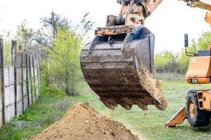 la excavadora moderna realiza trabajos de excavación en el sitio de construcción foto