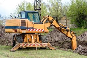 The modern excavator performs excavation work on the construction site photo