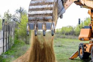 The modern excavator performs excavation work on the construction site photo