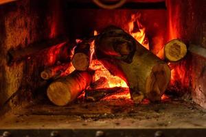 Fire burns inside fireplace to create warmth and atmosphere of comfort photo