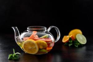 Hot fruit tea with lemon, mint, orange, lime and grapefruit photo