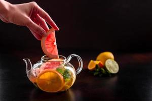 Hot fruit tea with lemon, mint, orange, lime and grapefruit photo