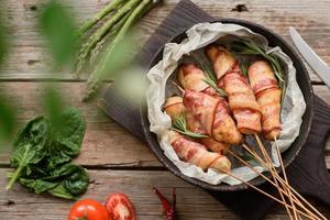 Roll with bacon and chicken mince on a stew with fresh asparagus photo