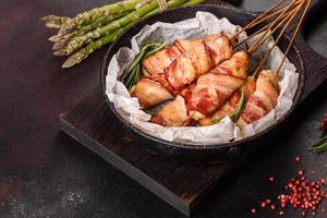 Roll with bacon and chicken mince on a stew with fresh asparagus photo