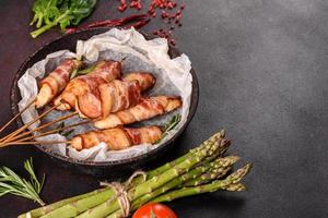 Roll with bacon and chicken mince on a stew with fresh asparagus photo