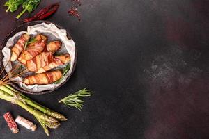 Roll with bacon and chicken mince on a stew with fresh asparagus photo