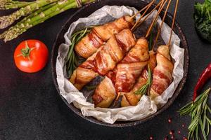 Roll with bacon and chicken mince on a stew with fresh asparagus photo