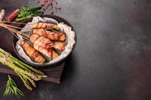 Roll with bacon and chicken mince on a stew with fresh asparagus photo